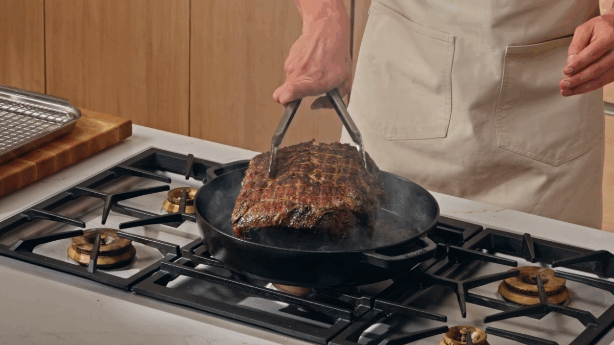 Nick DiGiovanni searing prime rib in a cast-iron skillet.