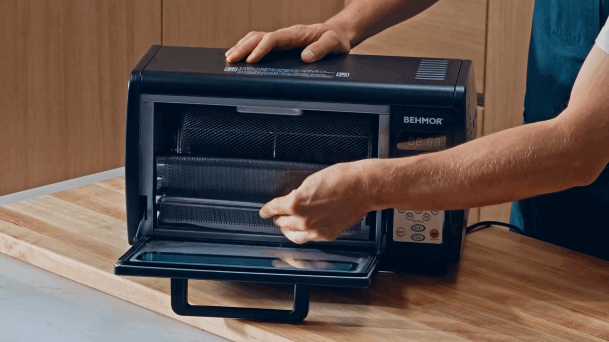 Nick DiGiovanni placing cacao beans in a roaster. 
