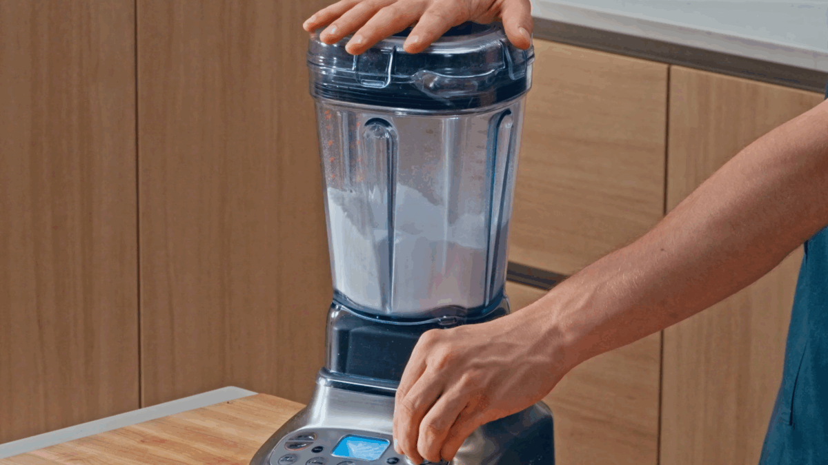 Nick DiGiovanni pulsing granulated sugar in a blender. 