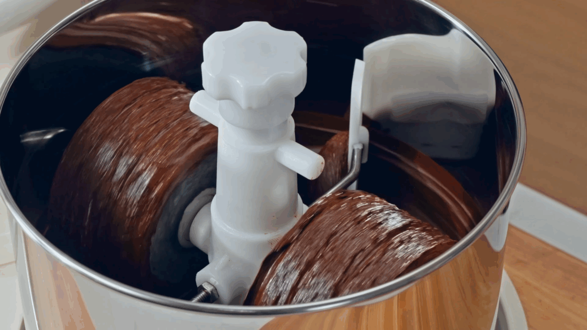 Cocoa liquor running in a melanger. 