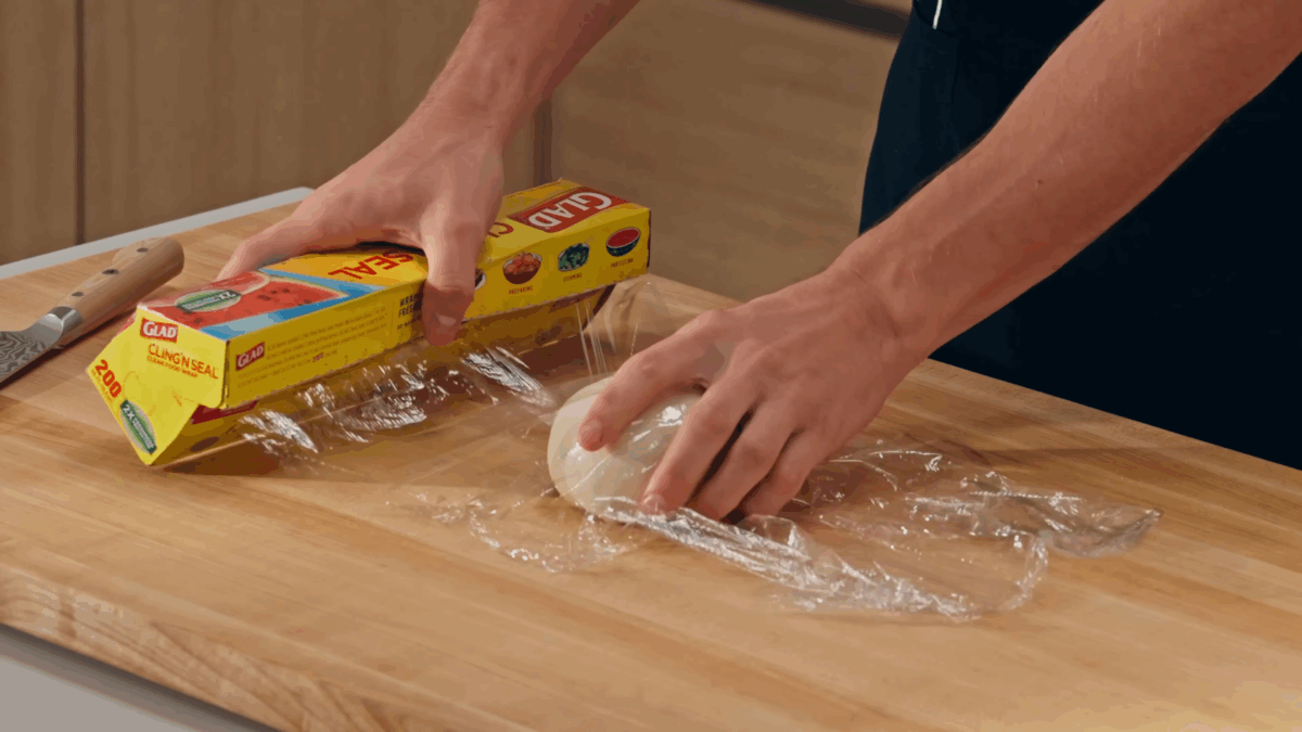 Nick DiGiovanni covering pork soup dumpling dough with plastic wrap. 