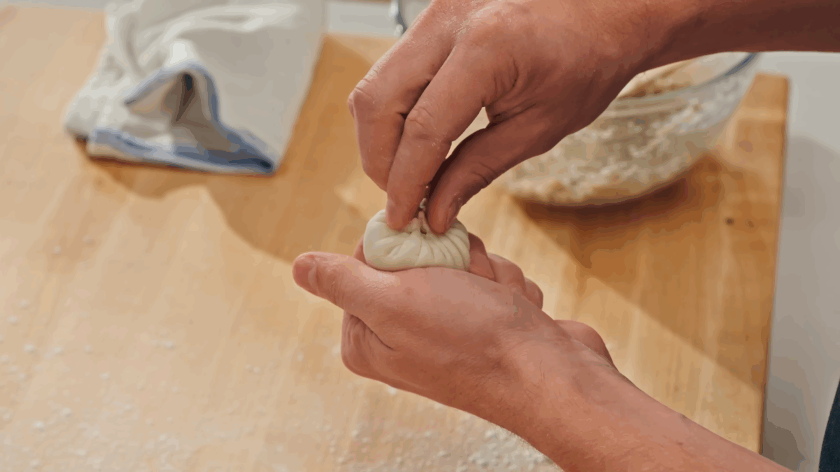 Nick DiGiovanni pleating a pork soup dumpling. 
