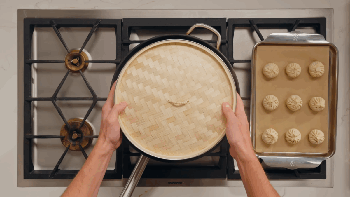 Nick DiGiovanni placing a steamer basket over a pot of simmering water. 