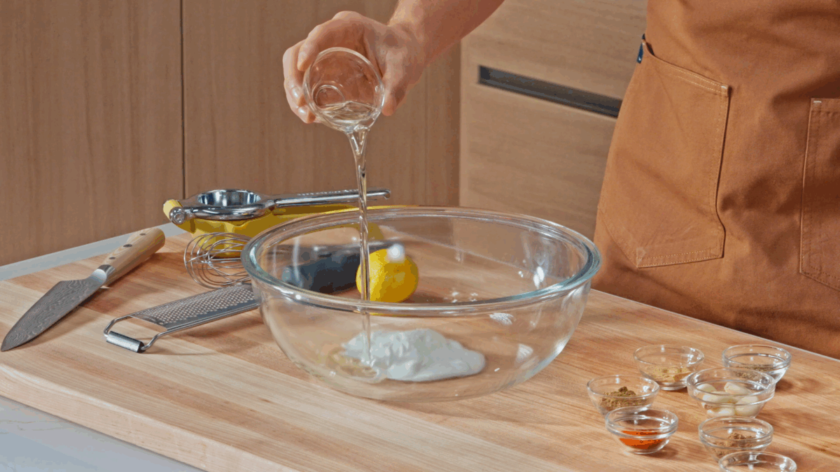Nick DiGiovanni combining ingredients for halal chicken marinade in a bowl.