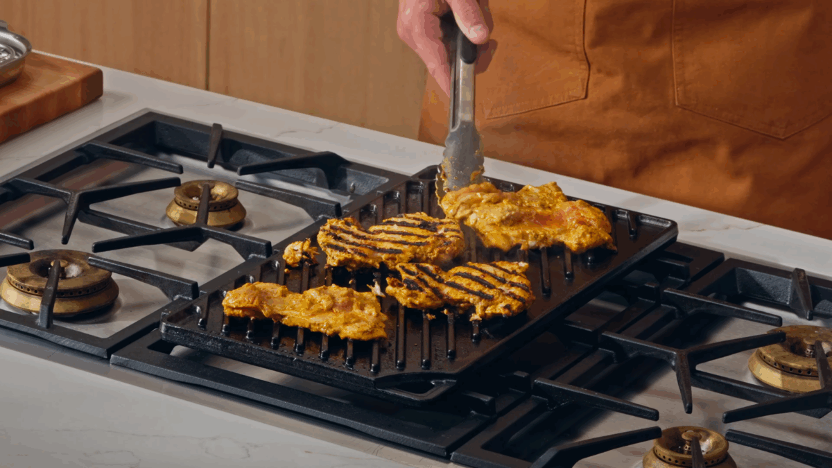Nick DiGiovanni cooking halal chicken on a grill pan.