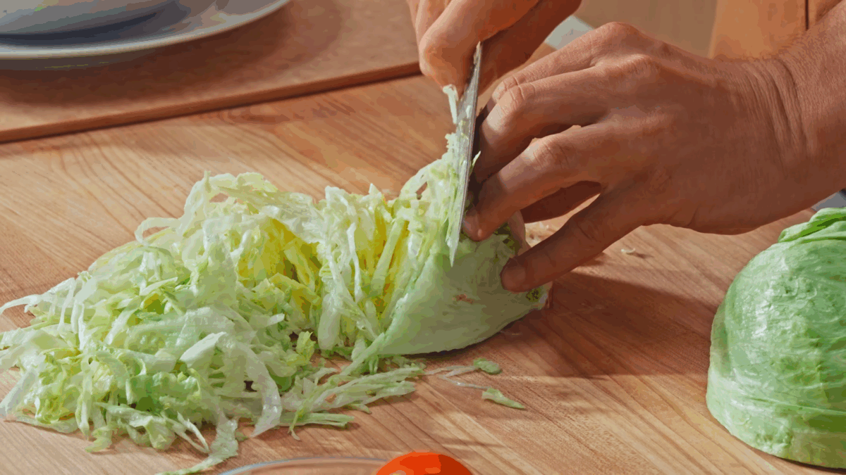 Nick DiGiovanni slicing half a head of lettuce.