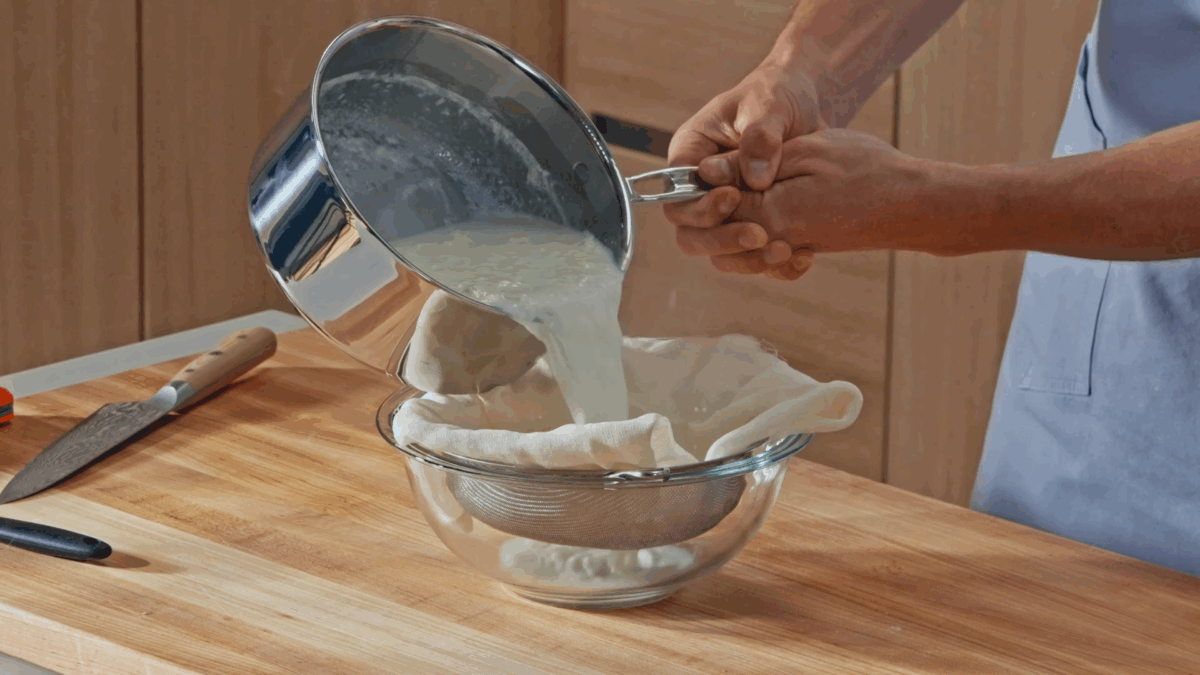 Nick DiGiovanni straining homemade cream cheese through a cheesecloth. 