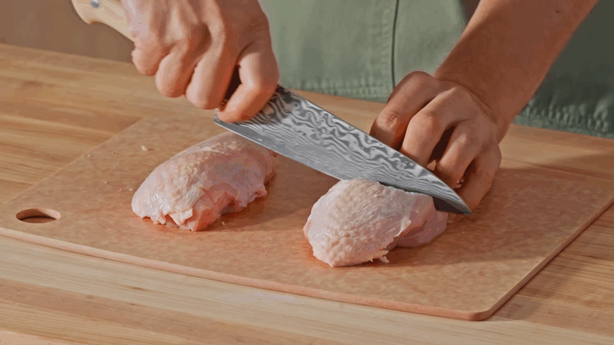 Nick DiGiovanni scoring raw chicken pieces. 