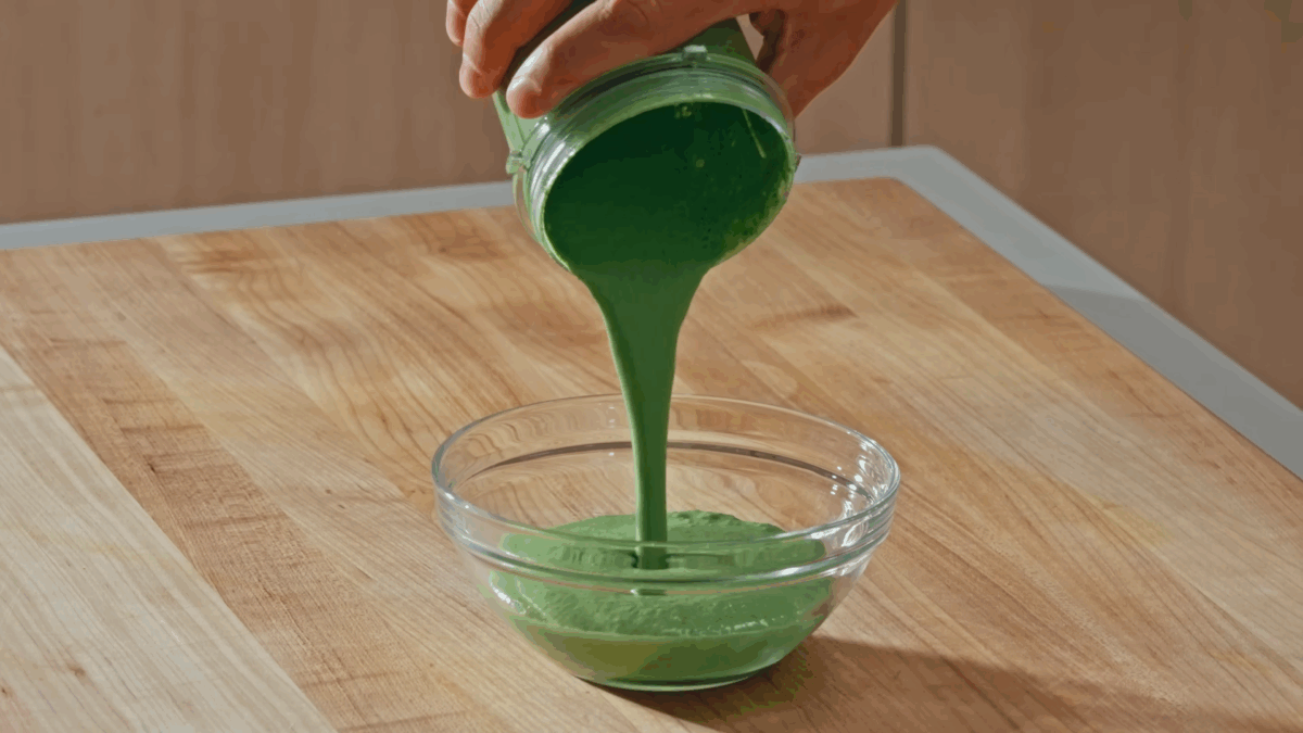 Nick DiGiovanni pouring mint-coriander chutney from a blender into a bowl. 