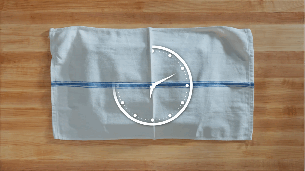 Naan dough proofing under a kitchen towel. 