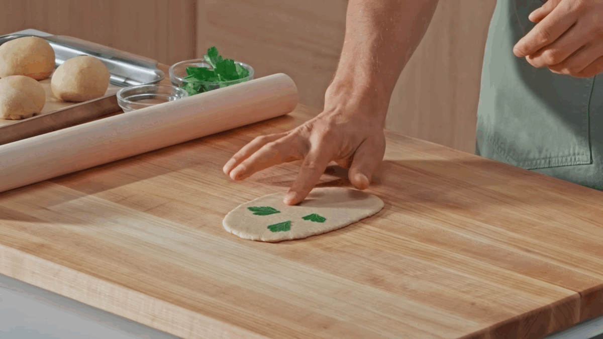 Nick DiGiovanni pressing parsley into naan dough. 