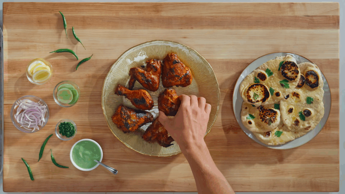 Nick DiGiovanni plating cooked tandoori chicken pieces. 