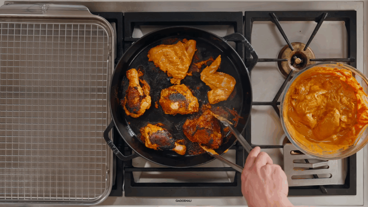 Nick DiGiovanni grilling tandoori chicken in a skillet. 