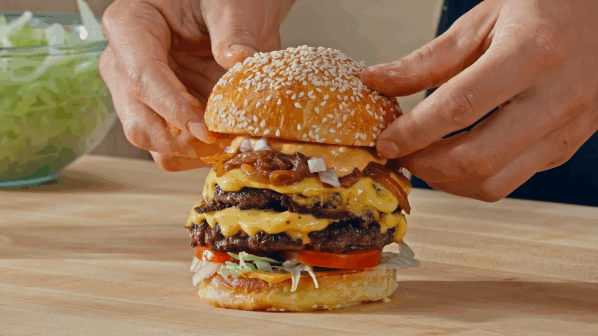 Nick DiGiovanni assembling a double cheeseburger.