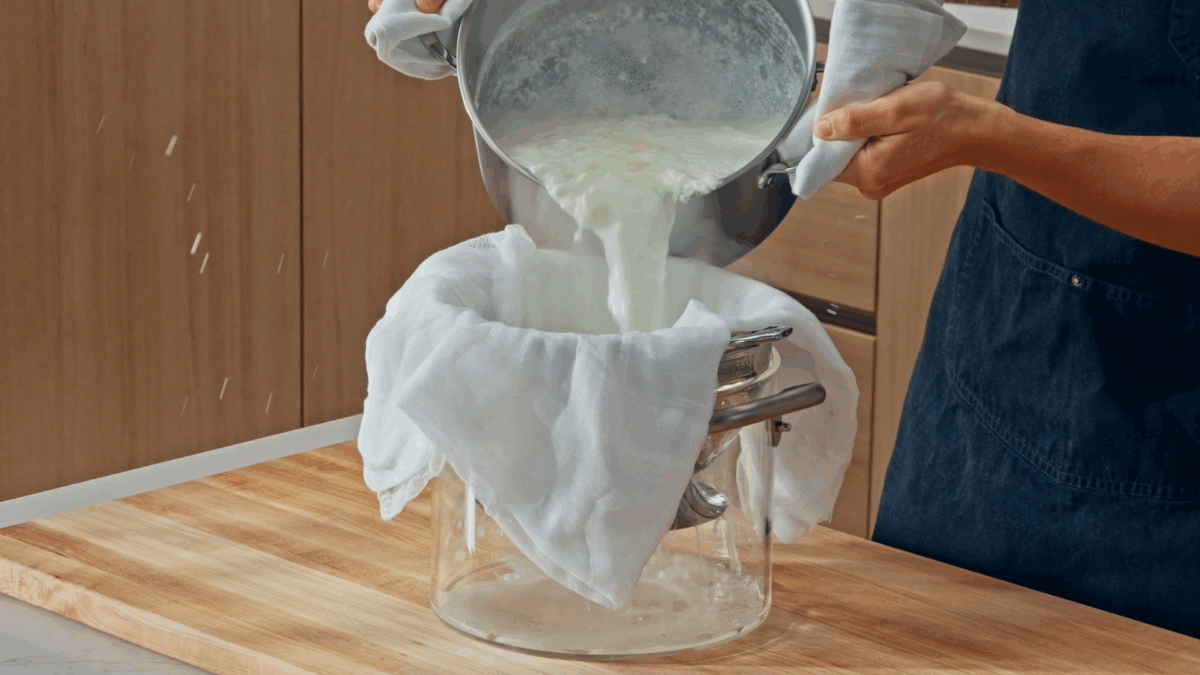 Nick DiGiovanni straining curds and whey through a cheesecloth. 