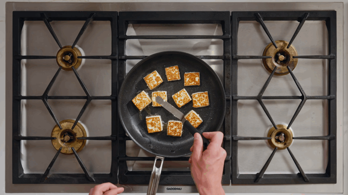 Nick DiGiovanni searing paneer cubes in a skillet. 