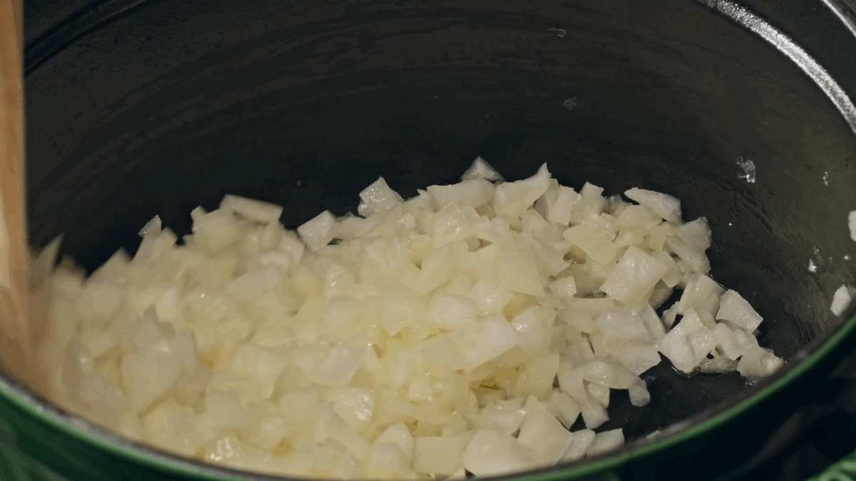 Diced onion cooking in a Dutch oven. 