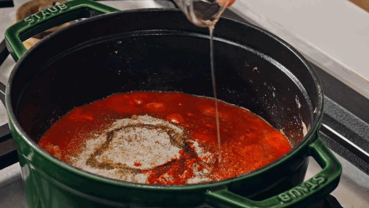 Nick DiGiovanni combining ingredients for butter masala gravy in a pot. 