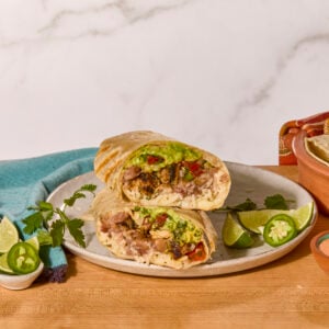 Two chicken burrito halves on a plate.