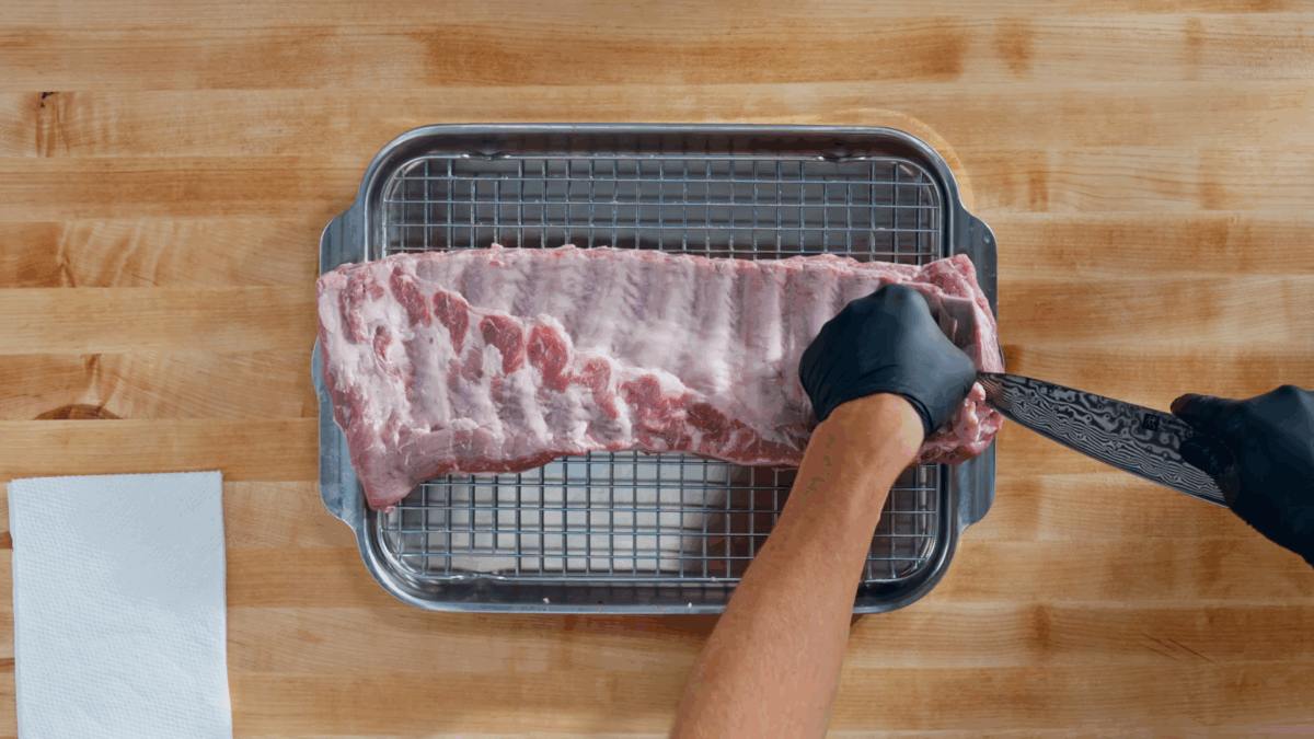 Nick DiGiovanni removing the silverskin from a rack of ribs.