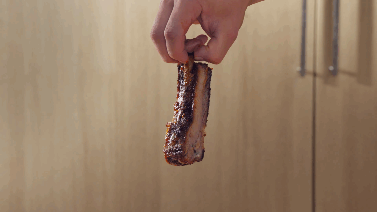 Nick DiGiovanni holding a St. Louis style pork rib.