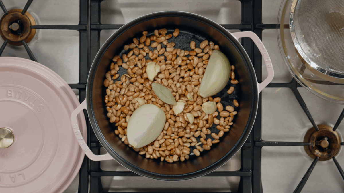 Soaked pinto beans and aromatics in a Dutch oven. 