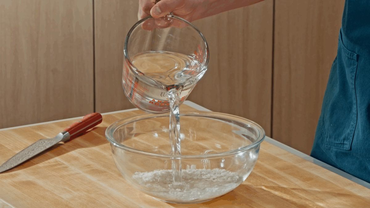 Nick DiGiovanni pouring water over a bowl of white rice. 