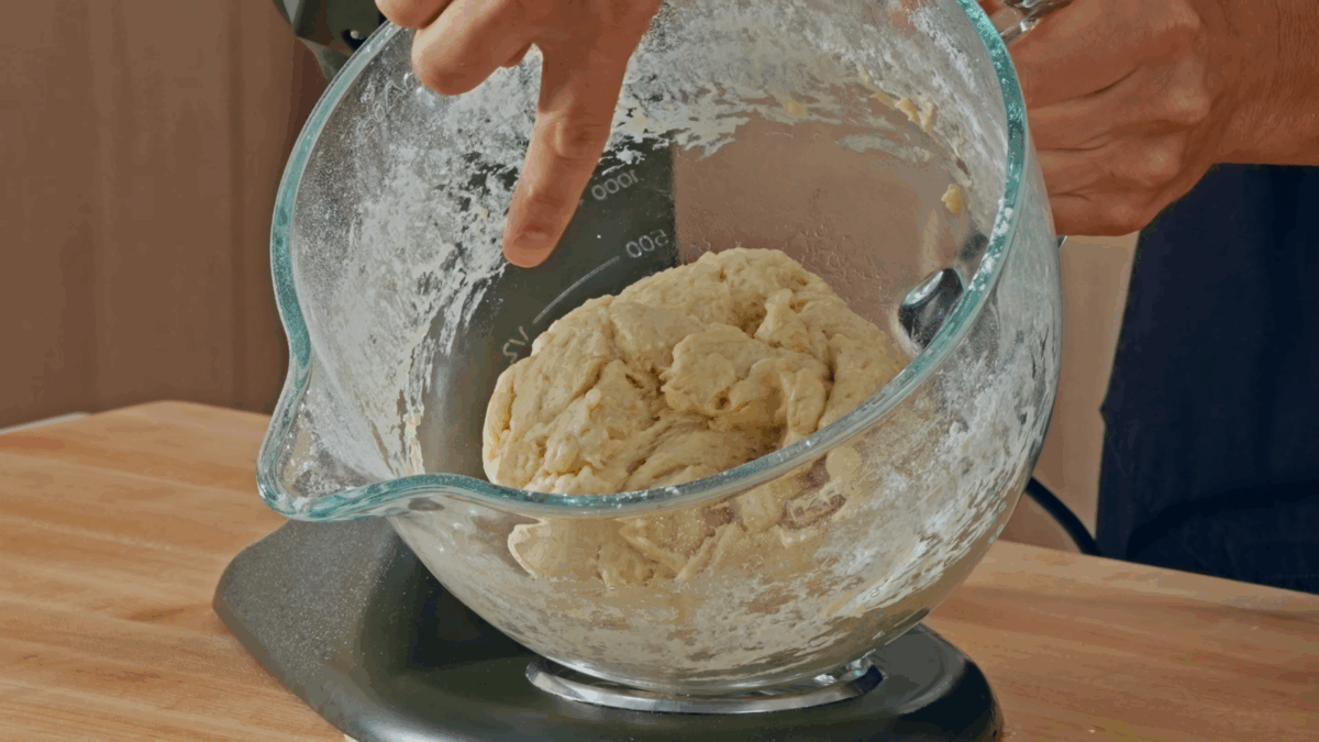 Deep dish pizza dough in the bowl of a stand mixer. 