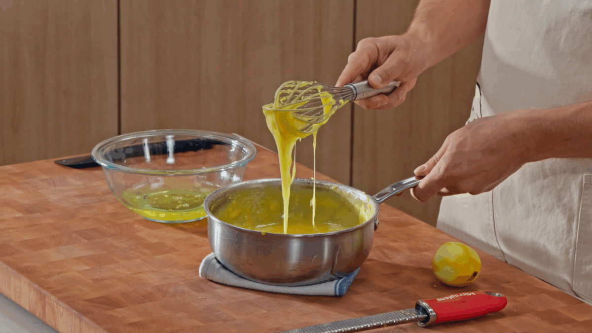 Nick DiGiovanni adding butter to a saucepan of lemon filling.