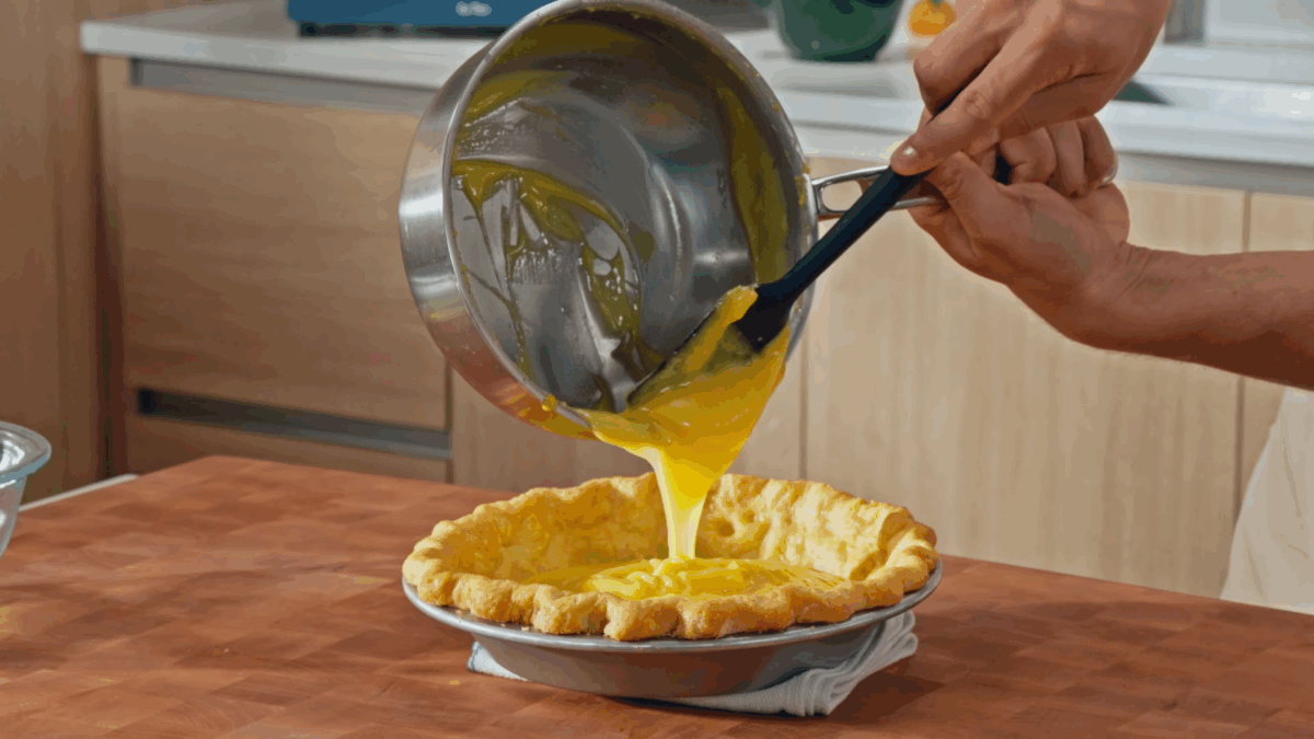 Nick DiGiovanni pouring lemon filling into an all-butter pie crust.