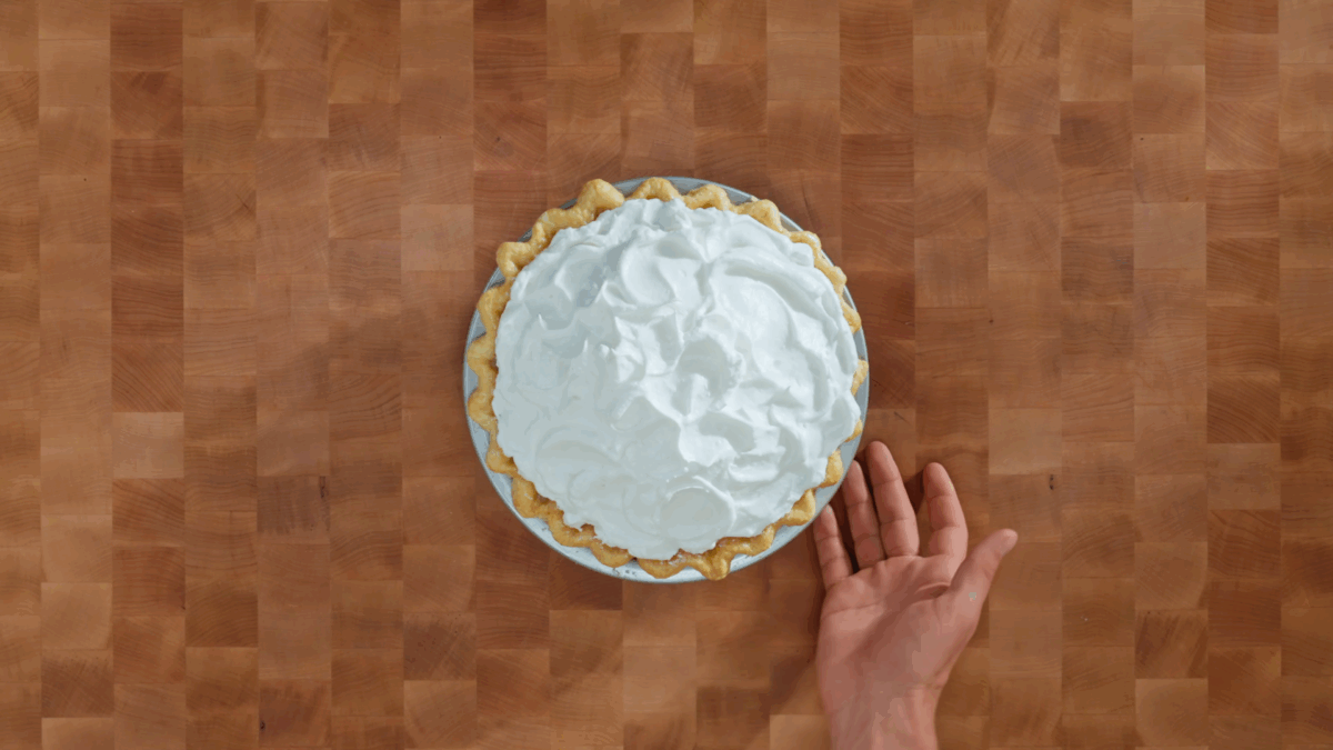 A baked lemon meringue pie on a wooden surface.