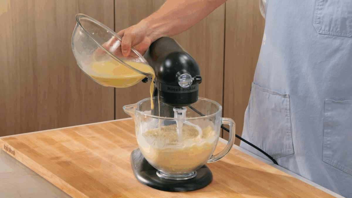 Nick DiGiovanni combining ingredients for a vanilla birthday cake recipe in the bowl of a stand mixer. 