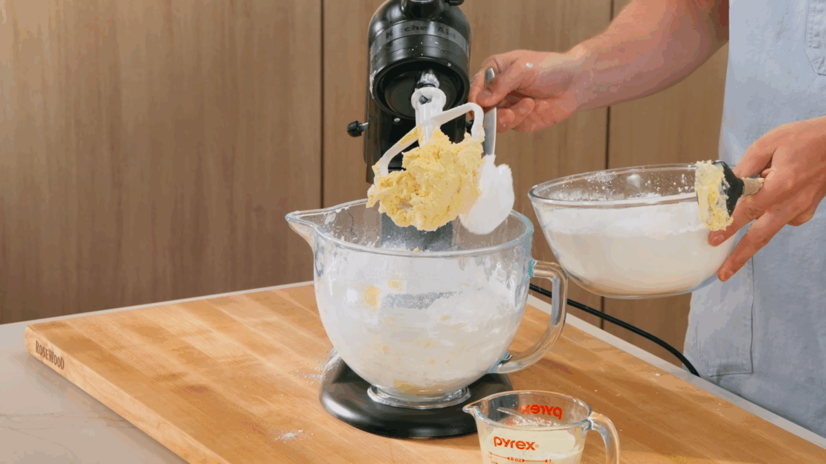 Nick DiGiovanni adding powdered sugar to a stand mixer of creamed butter. 