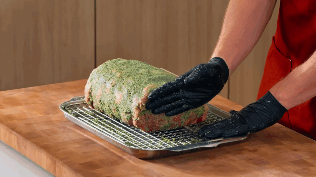 Nick DiGiovanni rubbing a salt-herb blend over a raw prime rib.