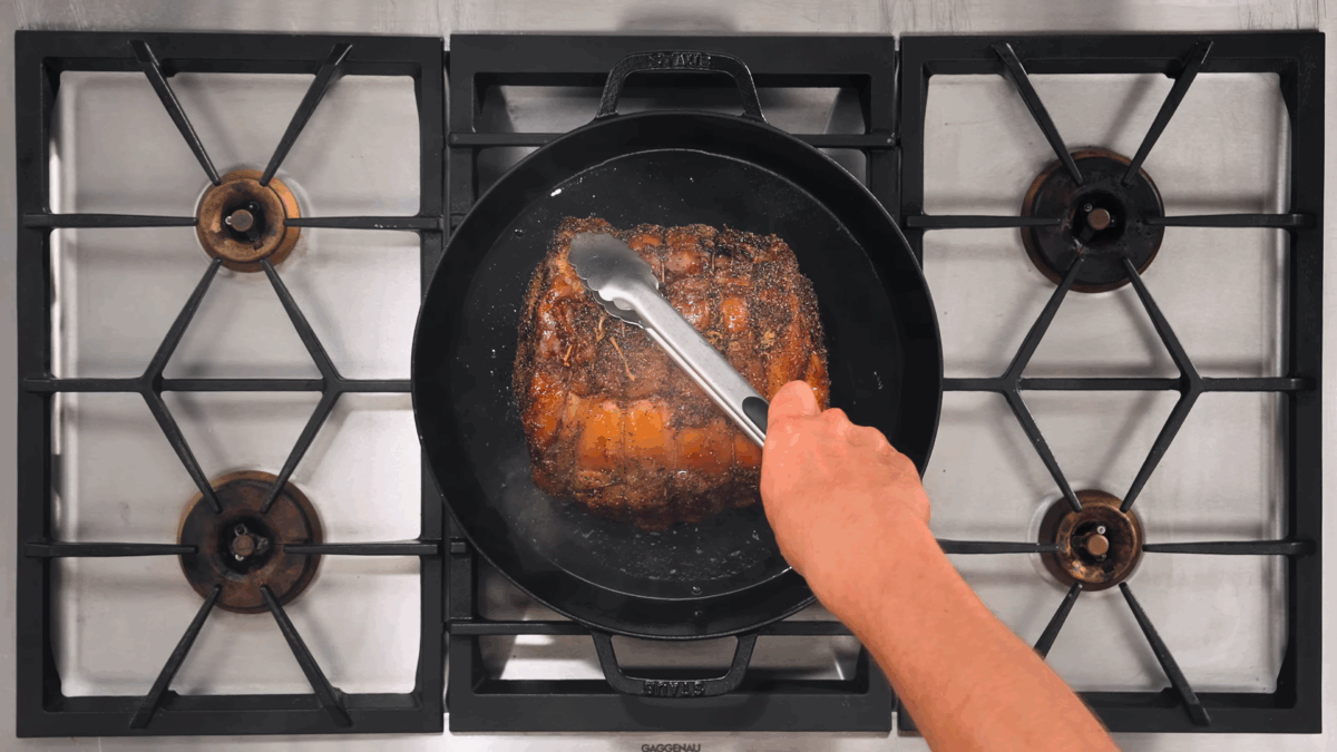 Nick DiGiovanni searing a prime rib roast in a cast iron skillet.