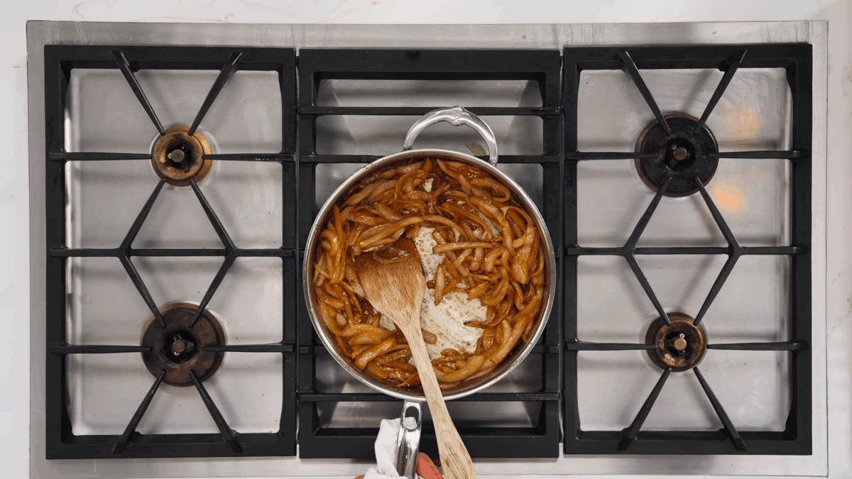 Caramelized onions in a pan on a stovetop.