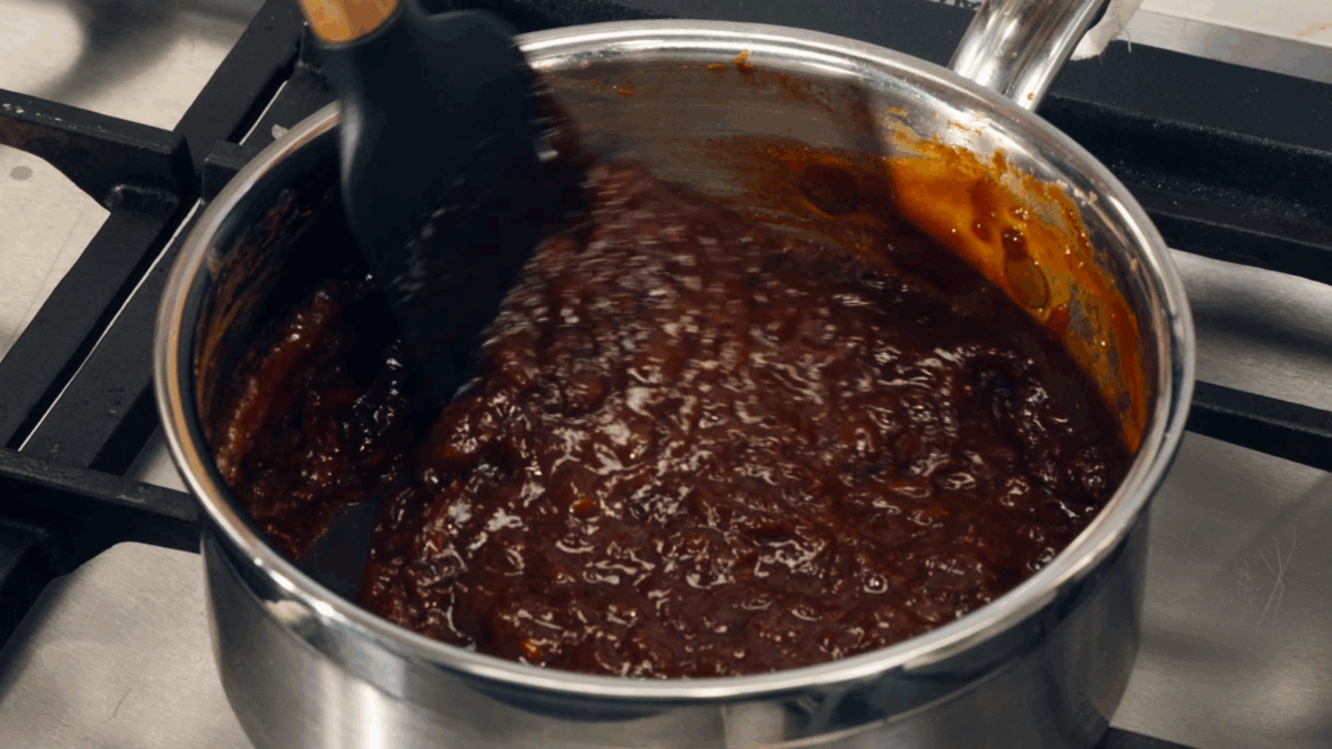 Nick DiGiovanni stirring tonkatsu sauce in a saucepan. 