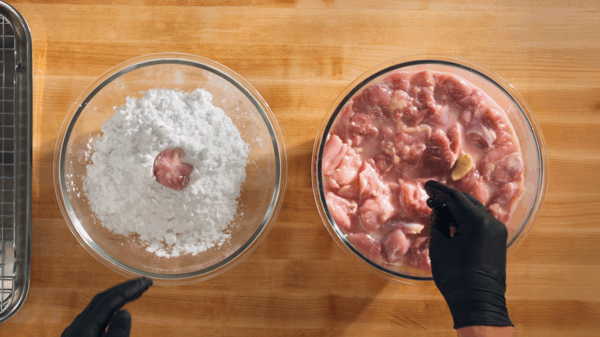 Nick DiGiovanni dredging marinated chicken pieces in potato starch.