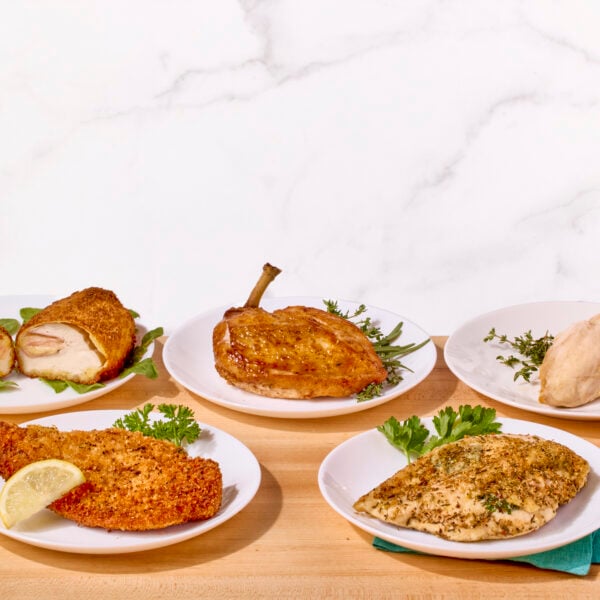 Five plates of chicken breasts prepared five different ways.