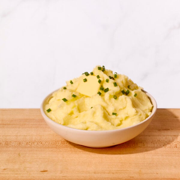 A bowl of Yukon gold mashed potatoes topped with chives.