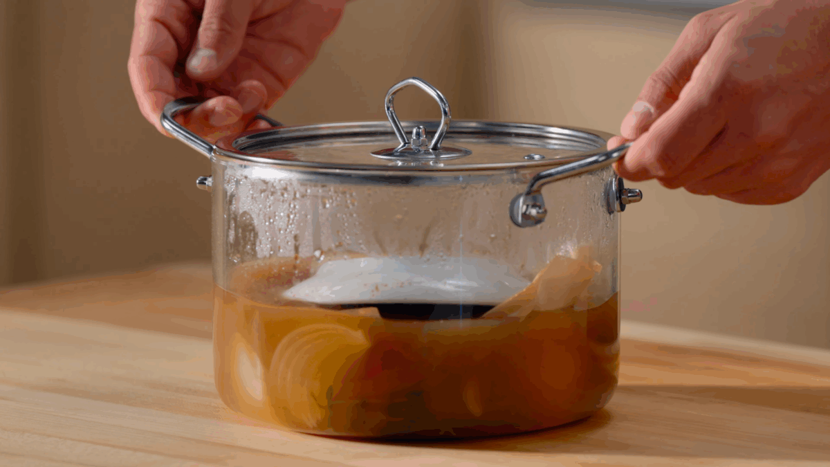 Nick DiGiovanni holding a pot of poached chicken.