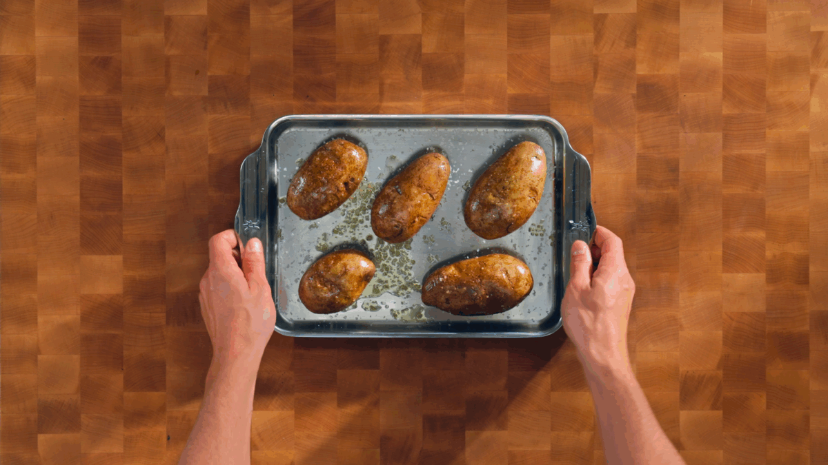 Nick DiGiovanni holding a baking sheet of seasoned potatoes. 