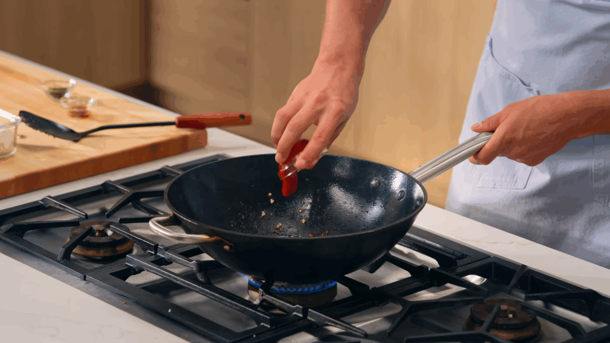 Nick DiGiovanni combining ingredients to make chicken fried rice in a skillet. 