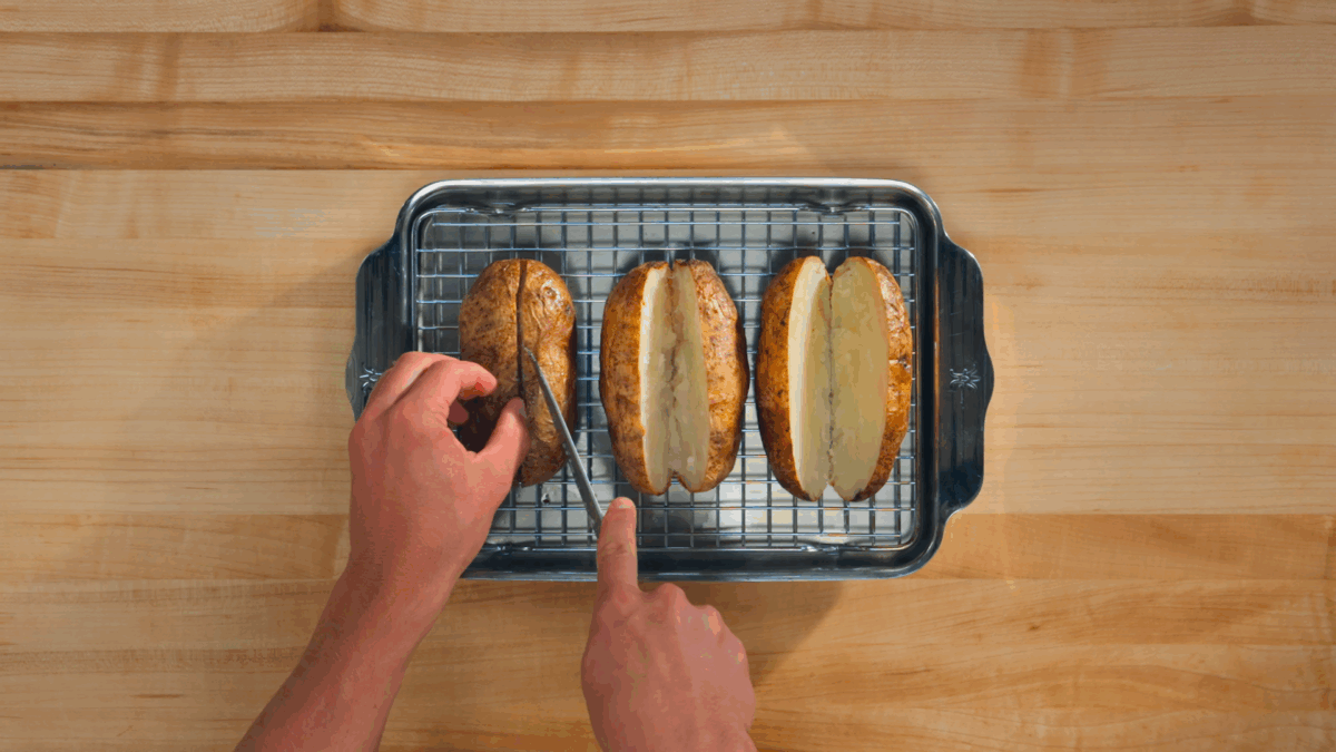 Nick DiGiovanni slicing baked potatoes open. 