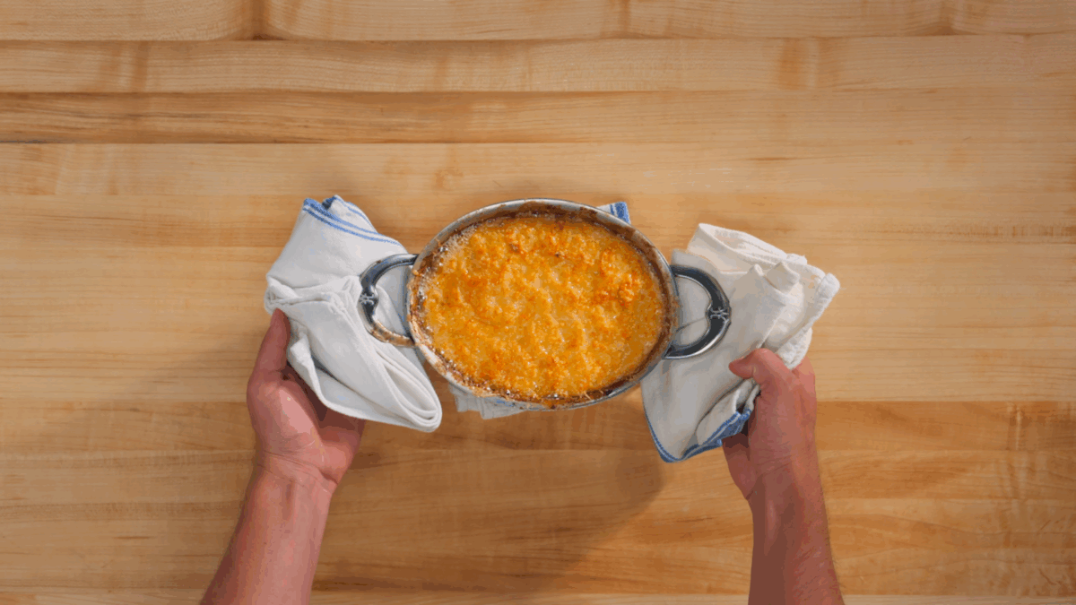 Nick DiGiovanni holding a baking dish of cheesy potato gratin. 