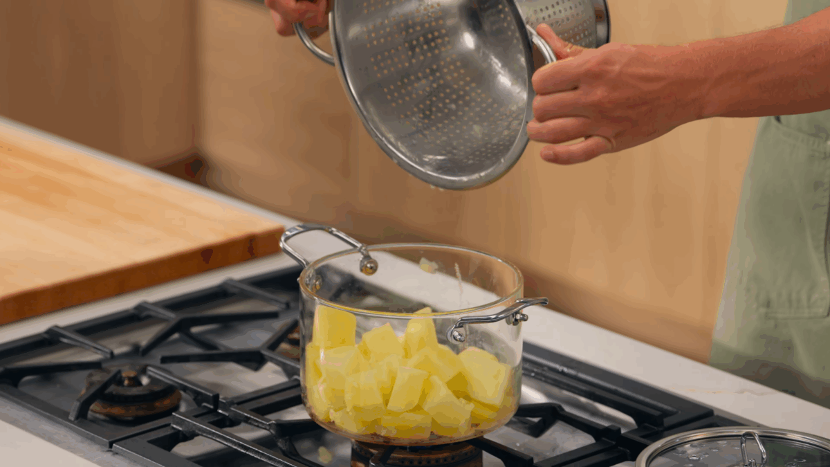 Nick DiGiovanni transferring boiled potatoes to a pot. 
