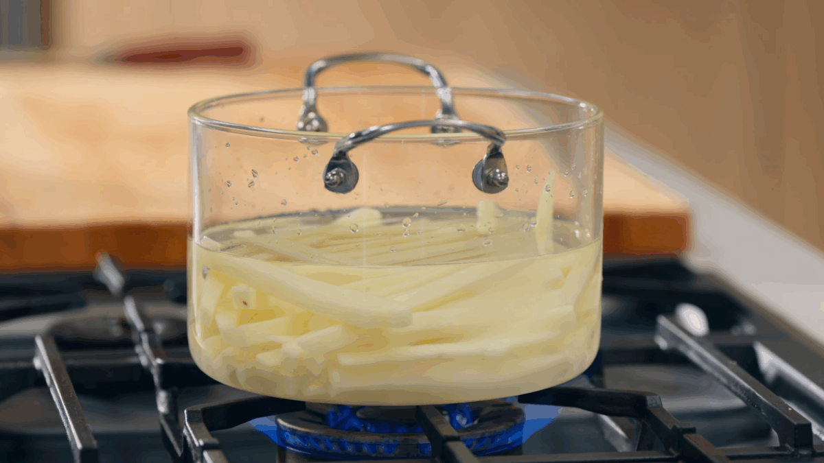 Fries being cooked in a pot of water.