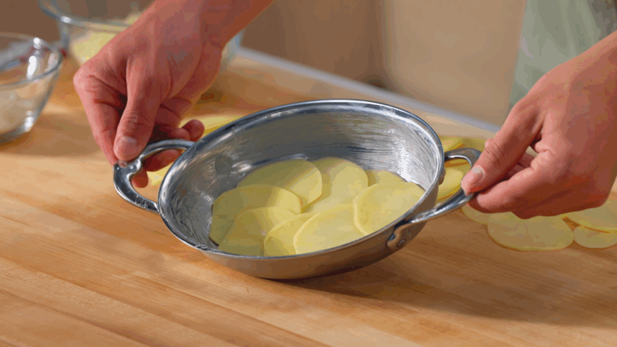 Nick DiGiovanni layering potatoes in a baking dish. 