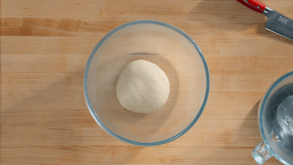 Bahn mi bread dough proofing in a bowl.