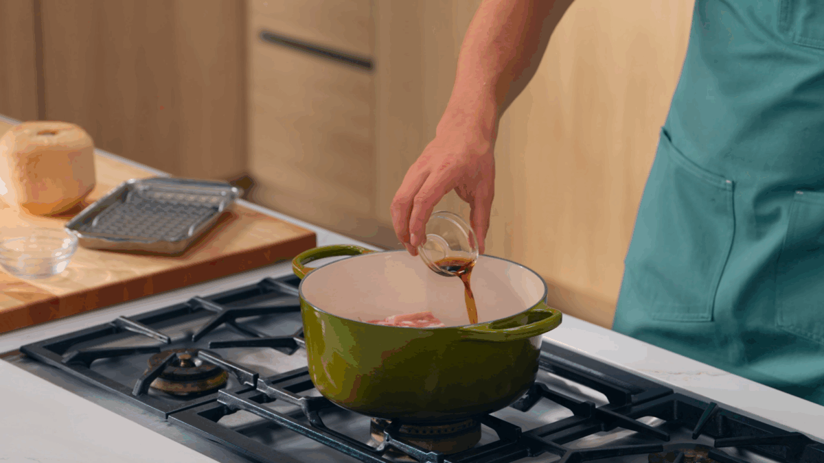 Nick DiGiovanni combining ingredients for caramelized pork in a Dutch oven.